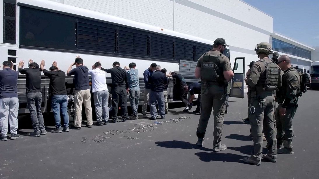 Manufacturing plant employees wait to have their legs shackled at the Hyundai–LG battery plant construction site, in Ellabell, Georgia, on September 4.