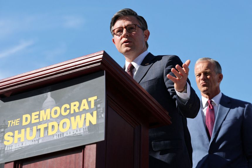 Speaker of the House Mike Johnson speaks as Senate Majority Leader John Thune looks on during a press conference on the first day of a partial government shutdown, outside the Capitol on Wednesday.