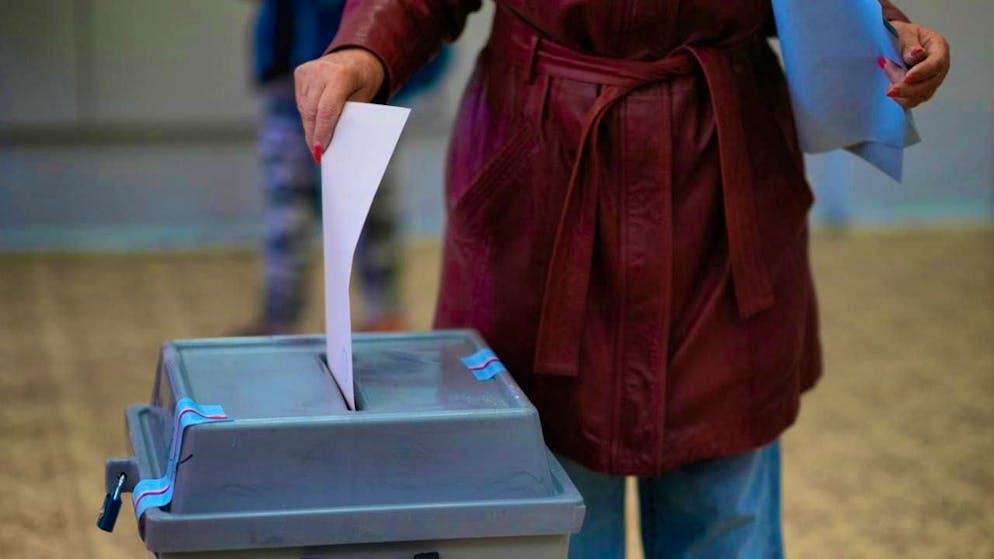 A woman casts her vote for the parliamentary elections at a polling station. Photo: Petr David Josek/AP/dpa