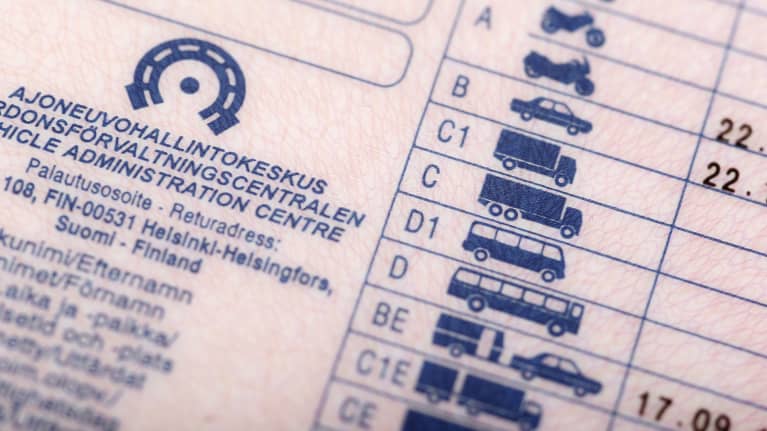 Close-up photo of a pink drivers' license with blue text and graphics.