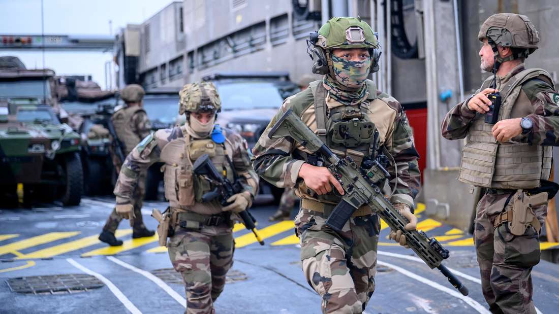 Zwei Soldaten verlassen rennend eine Fähre während einer Landungsübung.