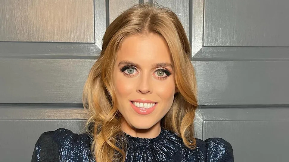  Princess Beatrice wearing a blue shimmery dress and smiling. 