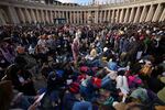 Faithful rest on the ground ahead of the funeral of Pope Francis in St. Peter's Square at the Vatican.