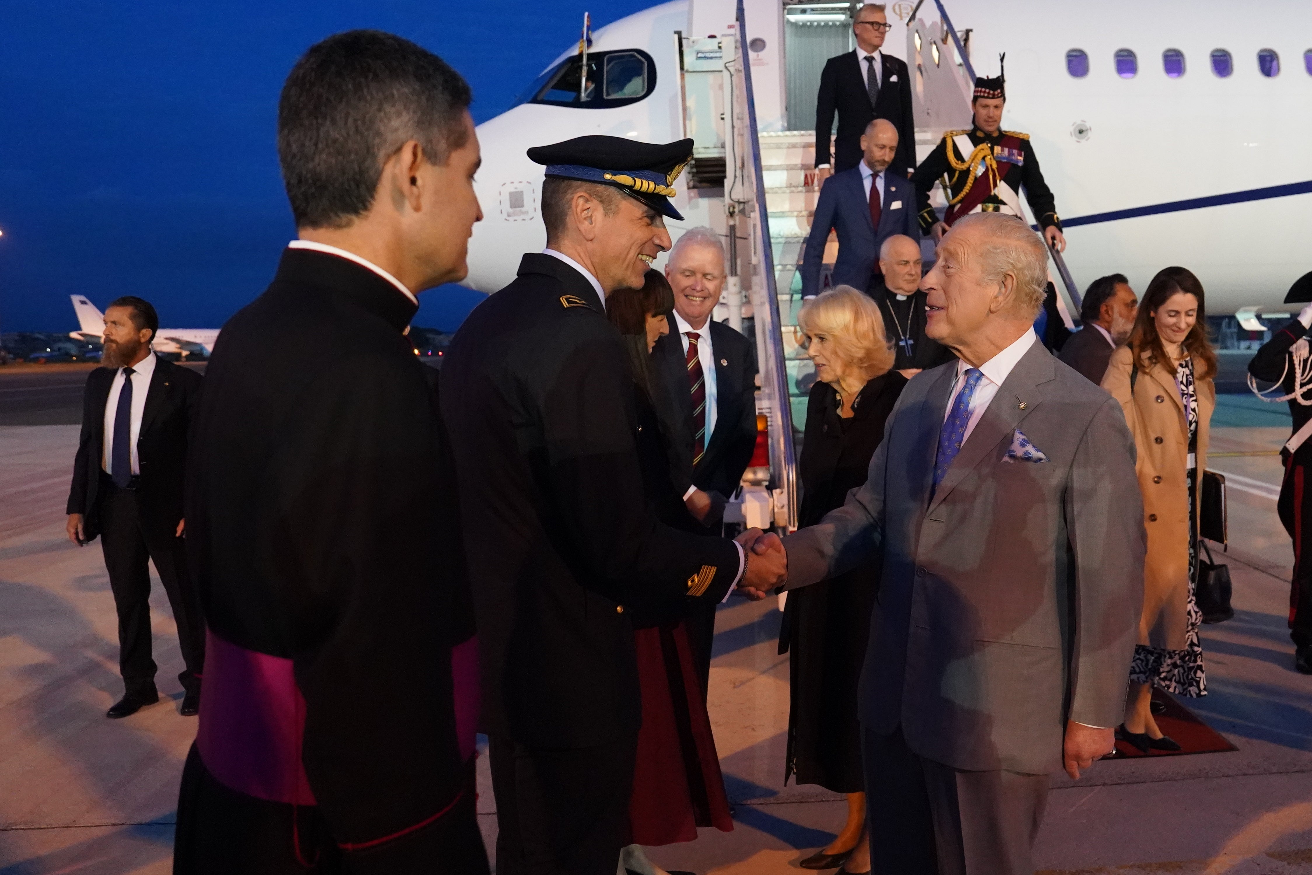 The King meets dignitaries after getting off the plane in Rome