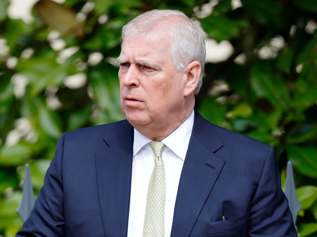 Prince Andrew frowning in blue suit
