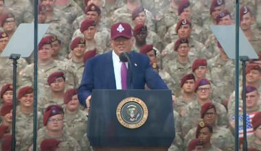 Donald Trump speaks and gestures to troops.