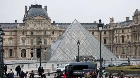 Reuters Police stand near the pyramid of the Louvre museum after reports of a robbery, in Paris, France, October 19, 2025