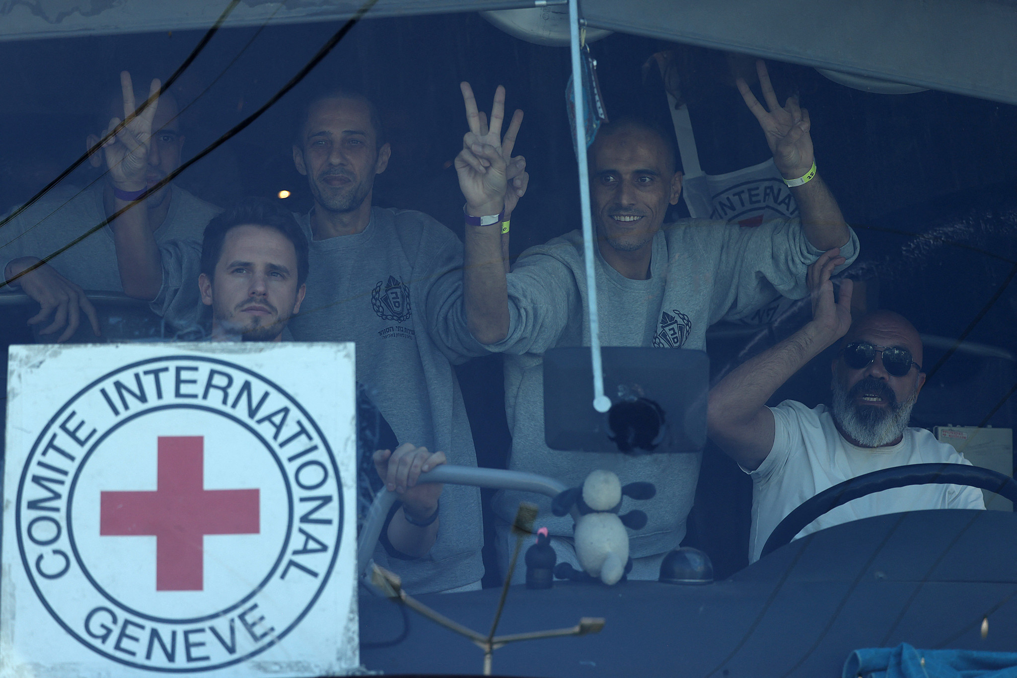 Des hommes palestiniens font des gestes depuis un bus après leur libération de la prison militaire d’Ofer en Cisjordanie occupée, le 13 octobre 2025, en échange d’otages détenus par le Hamas à Gaza.