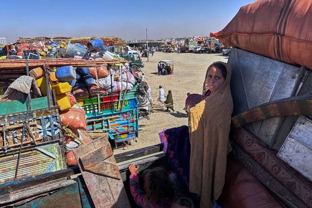 Young Afghan refugees on a truck loaded with belongings