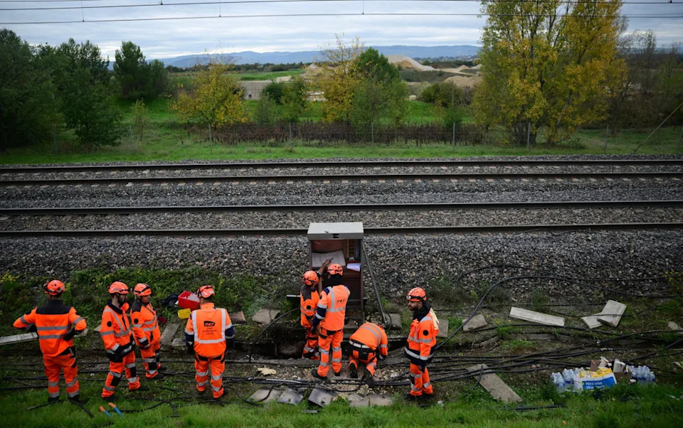 Workmen intervene next to charred cables and equipment south of Valence's TGV railway station