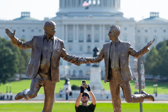 UNITED STATES - SEPTEMBER 23: A cyclist stops to take photos of a statue featuring President Donald Trump and Jeffrey Epstein dancing, titled "In Honor of Friendship Month," that appeared on the east end of the National Mall in Washington on Tuesday morning, September 23, 2025. (Bill Clark/CQ Roll Call via AP Images)