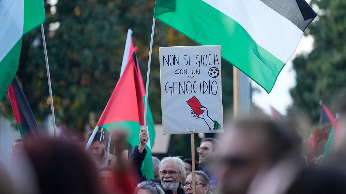 People hold a banner reading "you don't play with genocide" as they protest against the participation of the Israeli national team in the 2026 Soccer World Cup qualification match against Italy being played in the evening in Udine, Italy, Tuesday, Oct. 14, 2025
