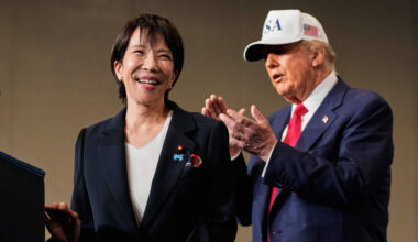 Japanese Prime Minister Sanae Takaichi, with President Donald Trump, reacts as she was speaking to members of the military aboard the USS George Washington, an aircraft carrier docked at an American naval base, in Yokosuka, Tuesday, Oct. 28, 2025. (Mark Schiefelbein/AP)