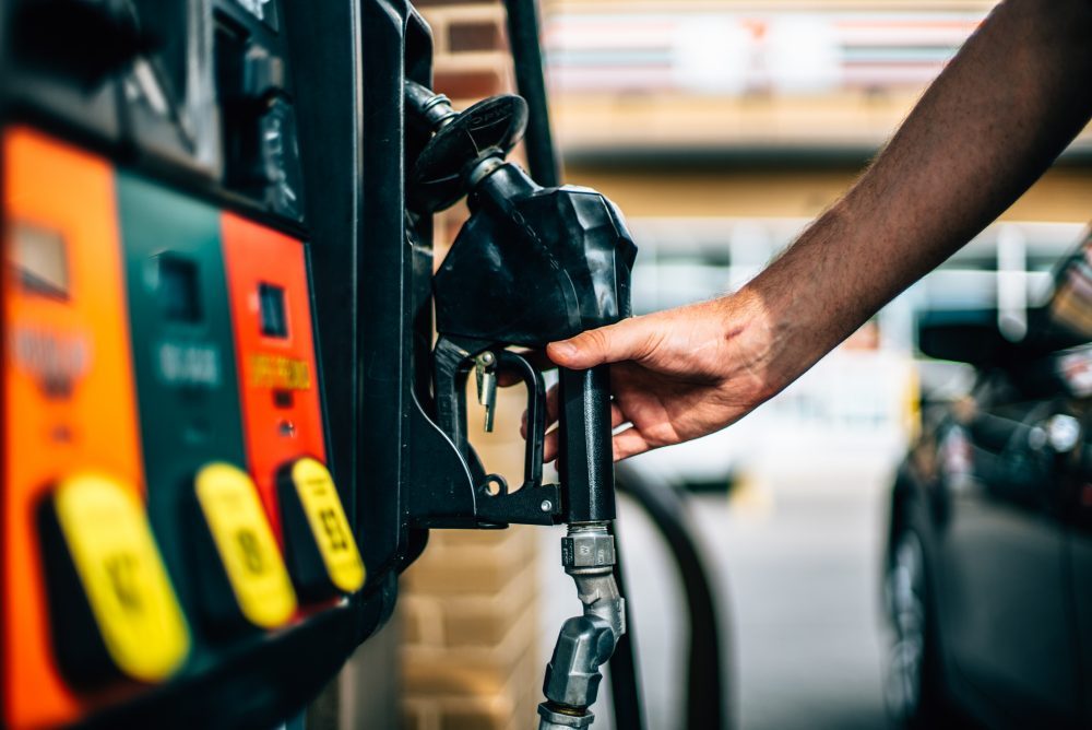 Gas pump with hand removing nozzle (WYDaily photo/Adobe)