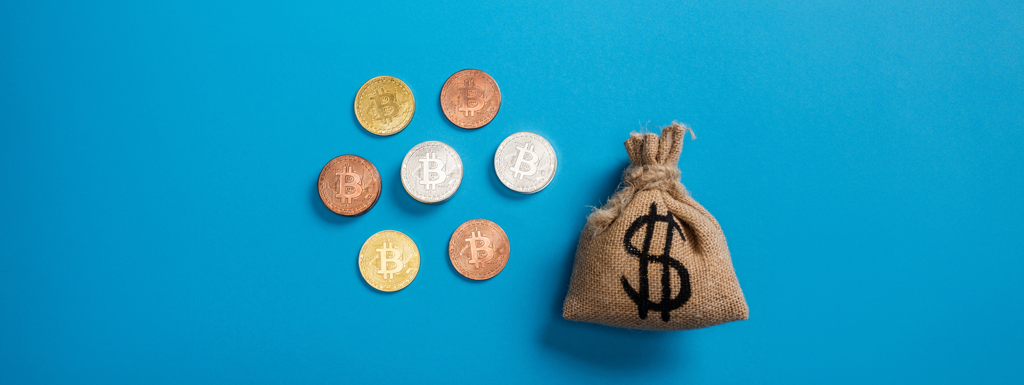 canvas money bag near bitcoins on blue background