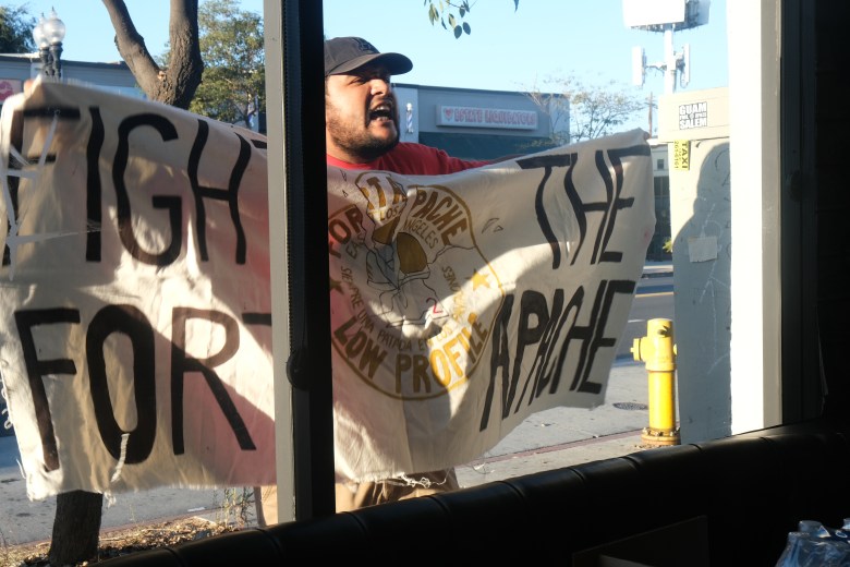 Gabriel Quiroz of the social justice group Centro CSO displaying a "Fight The Fort Apache" banner outside the Latino Community Town Hall on Thursday, Sept. 4.