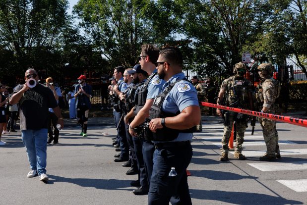 Chicago police assist federal officers as members of the community and activists protest near the 3900 block of South Kedzie Avenue on Oct. 4, 2025, in Chicago's Brighton Park neighborhood. (Armando L. Sanchez/Chicago Tribune)