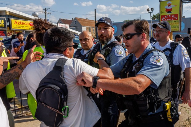 Chicago police push back activists and members of the community at a flash point with federal agents in the 3900 block of South Kedzie Avenue on Oct. 4, 2025, in Chicago. (Armando L. Sanchez/Chicago Tribune)
