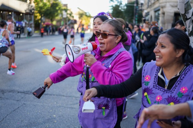 Aime Cabrera, of Las Doñas Run Club, cheers as runners in the Bank of America Chicago Marathon go by on 18th Street Oct. 12, 2025 in the Pilsen neighborhood of Chicago. (Eileen T. Meslar/Chicago Tribune)