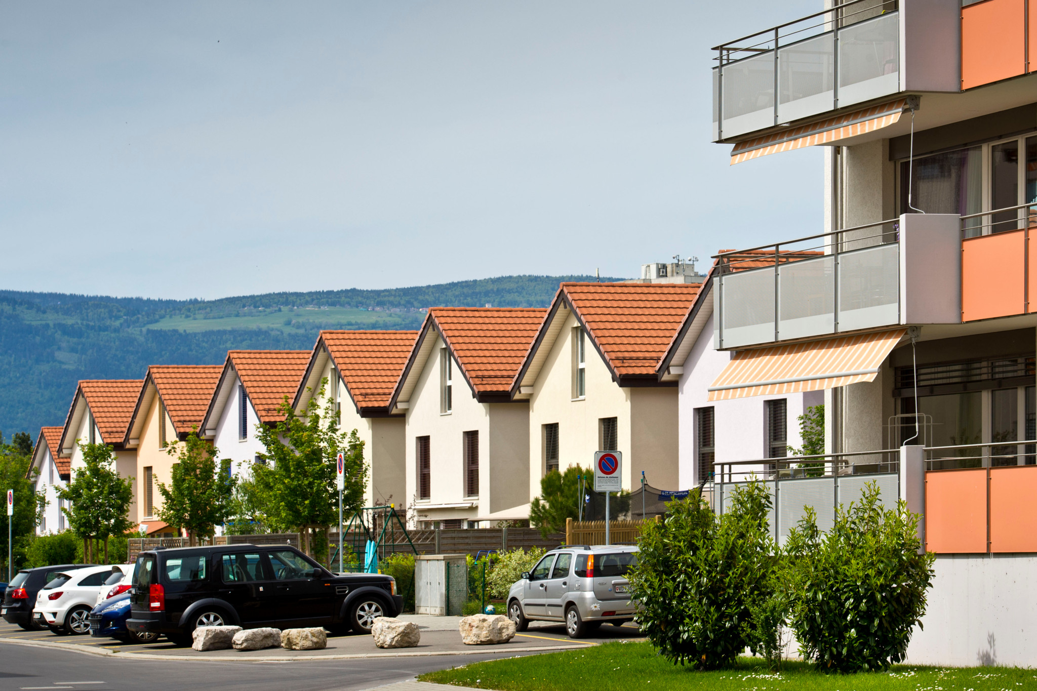 Quartier des Iles à Yverdon, avec maisons individuelles et immeubles locatifs, voitures garées au premier plan. Quartier des Iles à Yverdon, avec maisons individuelles et immeubles locatifs, voitures garées au premier plan.