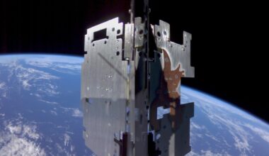 a metal cube-shaped device in the foreground with a blue-and-white earth in the background