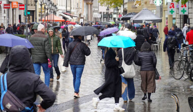 Shoppers With Umbrellas Walk Through Munich Pedestrian Zone On A Rainy Day