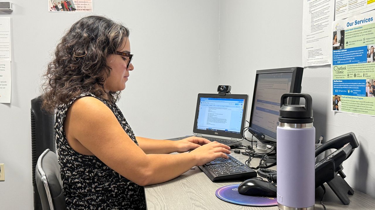 A mental health counselor works at the Mental Health Association of Central Florida, ready to help callers with crisis counseling. (Spectrum News)