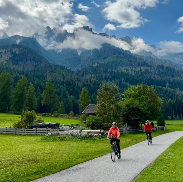 The mist-covered Dolomites hover over a couple of cyclists making their way along a bike path near San Candido, Italy, a town near the Austrian border. Virginia S. Mason