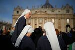 Nuns share a laugh as people gather for the funeral of Pope Francis in St. Peter's Square at the Vatican, Saturday, April 26, 2025. (AP Photo/Andreea Alexandru)
