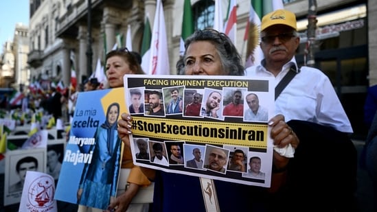 Protesters hold a placard against executions in Iran during a rally against the Iranian regime in Rome.(AFP)
