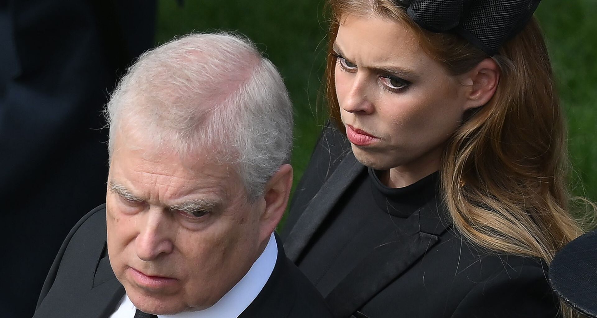 Prince Andrew looks stern wearing a suit and Princess Beatrice wears a black dress