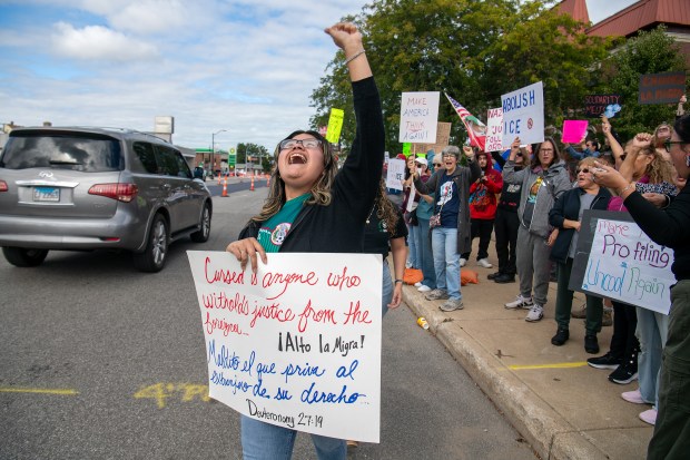 Angelica Bailon cheers as honking traffic passes by along Indianapolis Boulevard during anti-ICE protests outside East Chicago City Hall in East Chicago, Indiana, Saturday, Oct. 11, 2025. (Andy Lavalley/for the Post-Tribune)