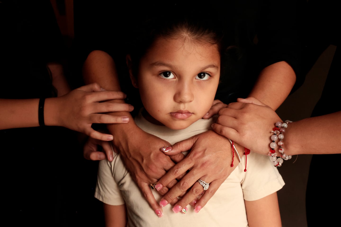 A girl, 5, stands for a portrait with her mother and sisters at their home in Leominster, Mass. last month after ICE agents arrested their father.