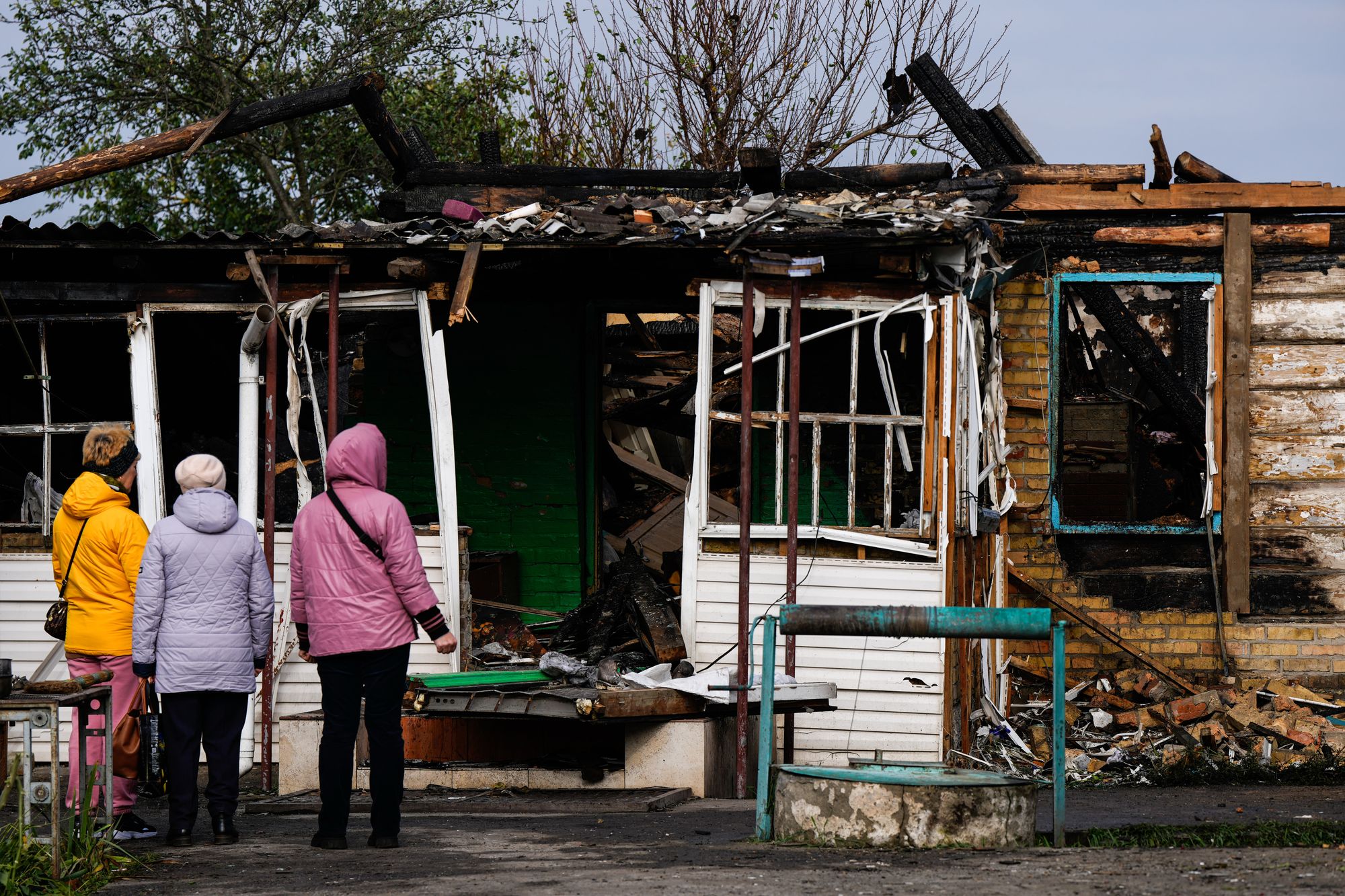 People look at a house damaged in a Russian attack, where a family was killed, on Wednesday