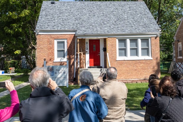 Tourists take pictures of Pope Leo XIV's childhood home during a bus tour stop in Dolton Sept. 6, 2025. (Troy Stolt/for the Daily Southtown)