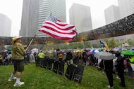 A demonstrators waves the American flag as rain fall on at Pacific Plaza Park during a 'No...