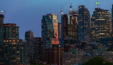 Image of the Toronto skyline with construction cranes rising above some buildings.