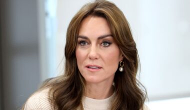 Kate Middleton has long brown hair and wears a cream sweater