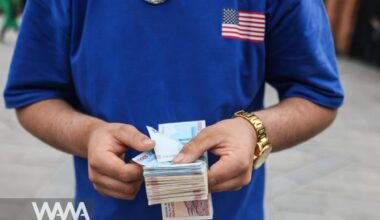 A currency dealer holds Iranian Rial bills at the Tehran Bazaar in Tehran