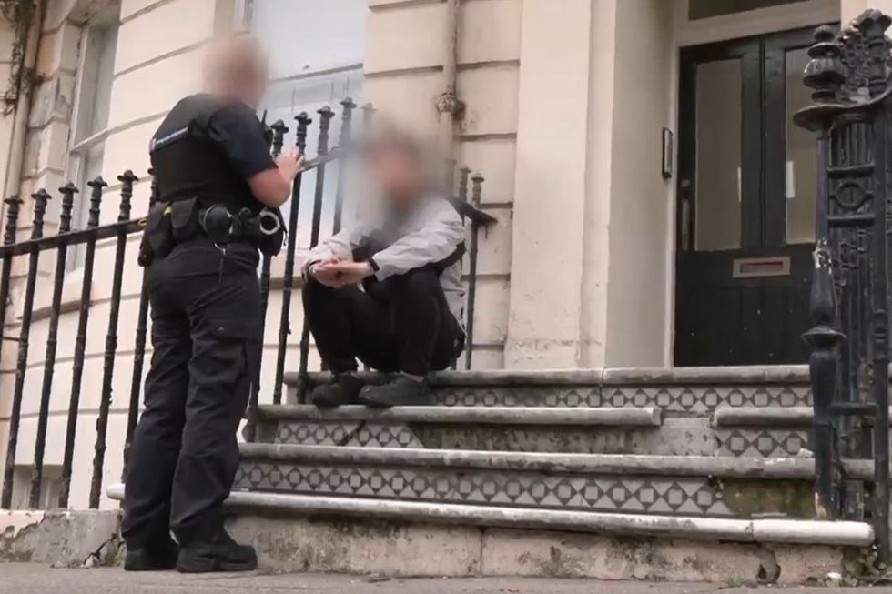 A law enforcement officer addresses a migrant found to have been working illegally