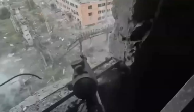 A Ukrainian soldier fires small arms at Russian soldiers assaulting his position