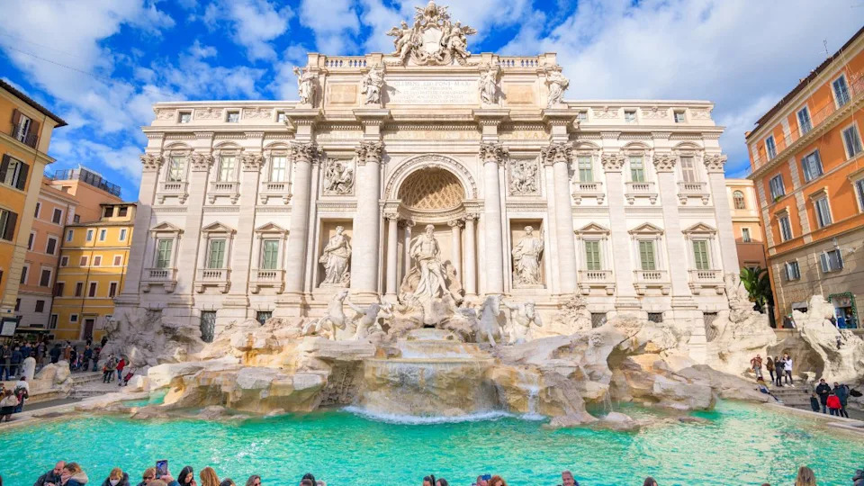 ROME, ITALY - DECEMBER 7, 2021: Visitors enjoy the historic 18th century Trevi Fountain on beautiful day.