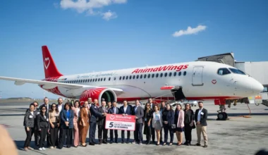 AnimaWings airline team celebrates the launch of new flights from Romania to Istanbul at the airport beside an aircraft.