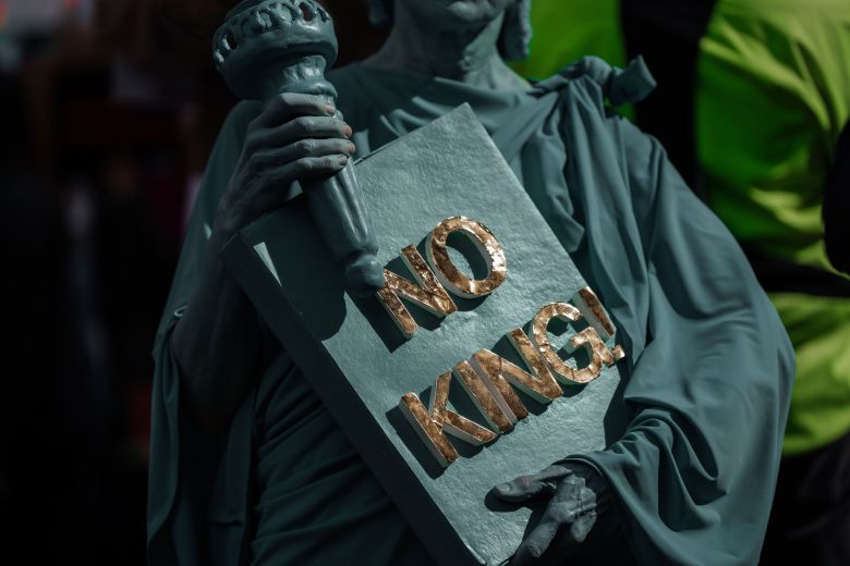 A protester dressed in a Statue of Liberty costume takes part in a 