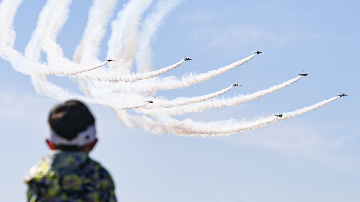 A child watches an aerobatic performance by the Air Force’s Black Eagles at the 2023 Seoul International Aerospace and Defense Exhibition (ADEX) at Seoul Air Base in Seongnam, Gyeonggi, Oct. 22, 2023. [YONHAP]
