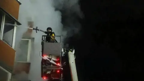 Ukrainian emergency service DSNS A firefighter tackles a fire in Kyiv