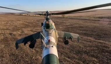 Tail view of a Ukrainian Mi-24 attack helicopter firing unguided rockets at a Russian position.