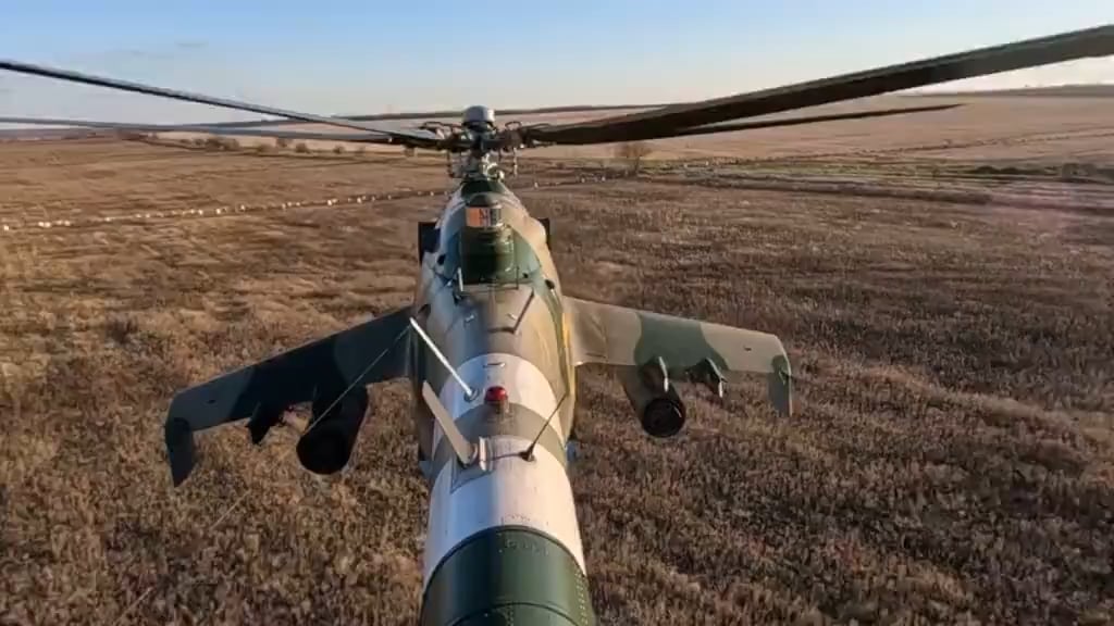 Tail view of a Ukrainian Mi-24 attack helicopter firing unguided rockets at a Russian position.