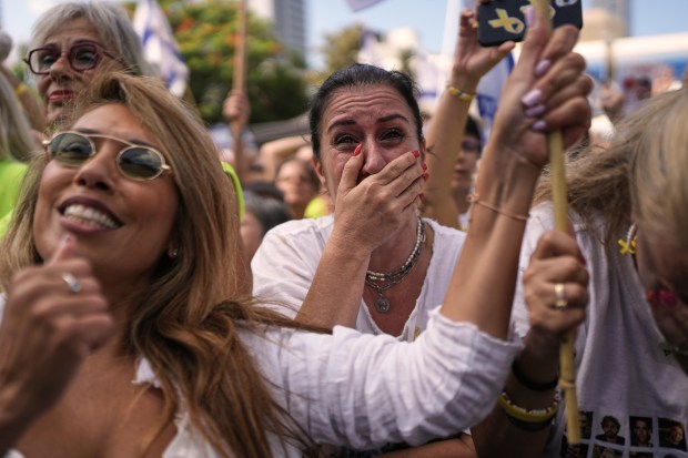 People react as they gather to watch a live broadcast...