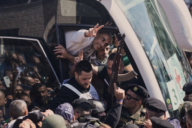 A Palestinian prisoner makes the victory sign after being released...